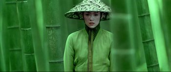 Movie still from “House of Flying Daggers” (2004), directed by Yimou Zhang – A woman wearing a green outfit and a straw hat; Medium shot, High angle