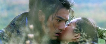 Movie still from “House of Flying Daggers” (2004), directed by Yimou Zhang – A man and a woman kissing in a forest; Close Up shot, Over the shoulder angle