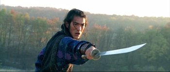 Movie still from “House of Flying Daggers” (2004), directed by Yimou Zhang – A man holding a sword in his hand; Medium shot, Over the shoulder angle