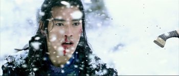 Movie still from “House of Flying Daggers” (2004), directed by Yimou Zhang – A man with blood on his face in the snow; Close Up shot, Over the shoulder angle