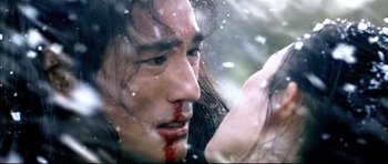 Movie still from “House of Flying Daggers” (2004), directed by Yimou Zhang – A person with blood on their face; Close Up shot, Over the shoulder angle