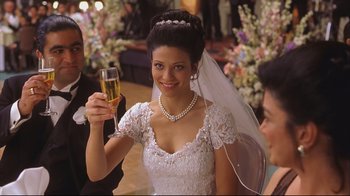 Movie still from “House of Sand and Fog” (2003), directed by Vadim Perelman – A woman in a white dress holding up a glass of champagne; Close Up shot, Over the shoulder angle