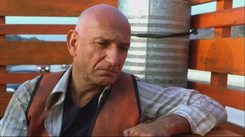Movie still from “House of Sand and Fog” (2003), directed by Vadim Perelman – A bald man in a vest looking down at his watch; Close Up shot, Low angle