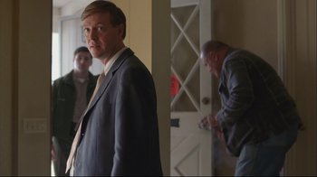 Movie still from “House of Sand and Fog” (2003), directed by Vadim Perelman – A man in a suit standing in front of a white door; Medium shot, Over the shoulder angle
