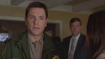 Movie still from “House of Sand and Fog” (2003), directed by Vadim Perelman – A man in a police uniform standing next to another man in a suit; Close Up shot, Over the shoulder angle