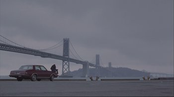 Movie still from “House of Sand and Fog” (2003), directed by Vadim Perelman – A car parked on the side of a road near a bridge; Extreme Wide shot, Low angle