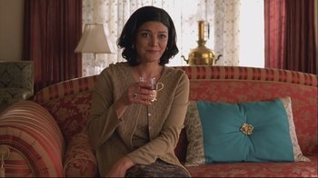Movie still from “House of Sand and Fog” (2003), directed by Vadim Perelman – A woman sitting on top of a couch holding a glass of wine; Medium shot, Over the shoulder angle