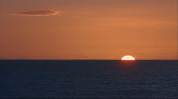 Movie still from “House of Sand and Fog” (2003), directed by Vadim Perelman – The sun is setting over the ocean with the sky in the background; Extreme Wide shot, High angle