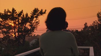 Movie still from “House of Sand and Fog” (2003), directed by Vadim Perelman – A woman standing on top of a deck watching the sunset; Medium shot, Low angle