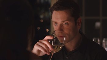 Movie still from “House of Sand and Fog” (2003), directed by Vadim Perelman – A person holding a glass of white wine; Close Up shot, Over the shoulder angle