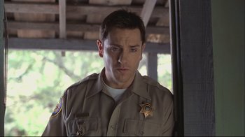 Movie still from “House of Sand and Fog” (2003), directed by Vadim Perelman – A man in a sheriff's uniform looking at the camera; Close Up shot, Low angle