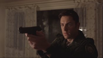 Movie still from “House of Sand and Fog” (2003), directed by Vadim Perelman – A man holding a gun in a room; Close Up shot, Low angle