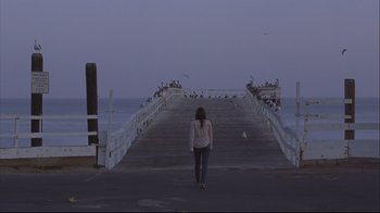 Movie still from “House of Sand and Fog” (2003), directed by Vadim Perelman – A woman is walking on a pier at dusk; Extreme Wide shot, High angle