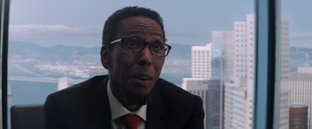 Movie still from “Venom” (2018), directed by Ruben Fleischer – A man in a black suit and red neck tie; Close Up shot, Over the shoulder angle