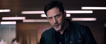 Movie still from “Venom” (2018), directed by Ruben Fleischer – A man in a leather jacket looking at the camera; Close Up shot, Over the shoulder angle
