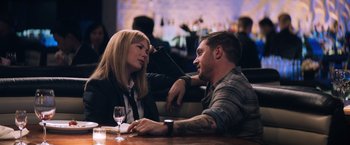 Movie still from “Venom” (2018), directed by Ruben Fleischer – A man and a woman are sitting at a table together; Medium shot, Over the shoulder angle