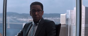 Movie still from “Venom” (2018), directed by Ruben Fleischer – A man in a suit and tie sitting in a chair; Close Up shot, Over the shoulder angle