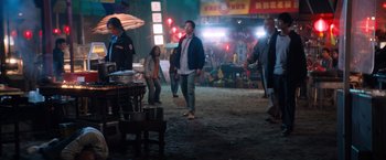 Movie still from “Venom” (2018), directed by Ruben Fleischer – A group of people walking on a street at night; Wide shot, Over the shoulder angle