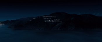 Movie still from “Venom” (2018), directed by Ruben Fleischer – A view of a city lit up at night from the water; Extreme Wide shot, High angle