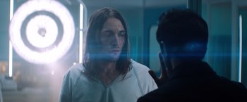 Movie still from “Venom” (2018), directed by Ruben Fleischer – A man with long brown hair is looking in the mirror; Close Up shot, Over the shoulder angle