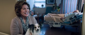 Movie still from “Venom” (2018), directed by Ruben Fleischer – An older woman sitting in a room with a small dog; Close Up shot, Over the shoulder angle