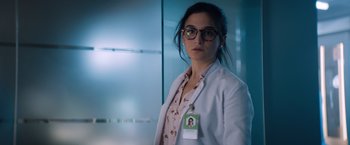 Movie still from “Venom” (2018), directed by Ruben Fleischer – A woman in a white lab coat with a name tag on it; Close Up shot, Over the shoulder angle