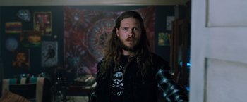 Movie still from “Venom” (2018), directed by Ruben Fleischer – A man with long hair wearing a black jacket; Medium shot, Over the shoulder angle