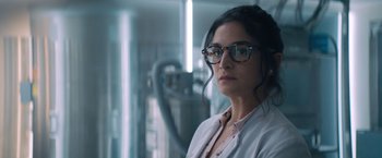 Movie still from “Venom” (2018), directed by Ruben Fleischer – A woman wearing glasses and a lab coat in a room; Close Up shot, Low angle