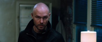 Movie still from “Venom” (2018), directed by Ruben Fleischer – A man with a shaved head and a black jacket; Close Up shot, Low angle