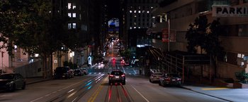 Movie still from “Venom” (2018), directed by Ruben Fleischer – A car driving down a street at night time; Extreme Wide shot, High angle