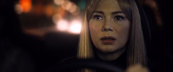 Movie still from “Venom” (2018), directed by Ruben Fleischer – A person in a car with lights in the background; Close Up shot, Over the shoulder angle
