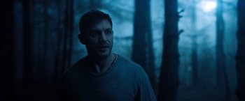 Movie still from “Venom” (2018), directed by Ruben Fleischer – A person in a forest near trees; Close Up shot, Over the shoulder angle