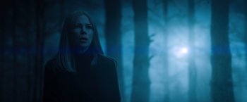 Movie still from “Venom” (2018), directed by Ruben Fleischer – A woman standing in front of a forest at night; Medium shot, Low angle