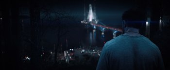 Movie still from “Venom” (2018), directed by Ruben Fleischer – A man standing in front of a bridge at night; Medium shot, Low angle