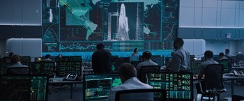 Movie still from “Venom” (2018), directed by Ruben Fleischer – A group of people sitting in front of computer screens; Wide shot, Over the shoulder angle