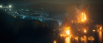 Movie still from “Venom” (2018), directed by Ruben Fleischer – An aerial view of a bridge with a fire in the background; Extreme Wide shot, High angle
