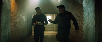 Movie still from “Venom” (2018), directed by Ruben Fleischer – Two police officers talking to each other in a jail cell; Medium shot, Over the shoulder angle