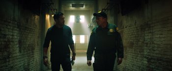 Movie still from “Venom” (2018), directed by Ruben Fleischer – Two police officers are walking in a hallway; Medium shot, Low angle