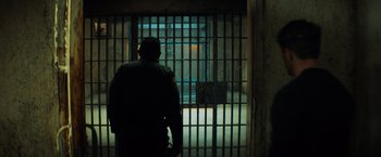 Movie still from “Venom” (2018), directed by Ruben Fleischer – A man standing in front of a jail cell; Wide shot, High angle