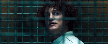 Movie still from “Venom” (2018), directed by Ruben Fleischer – A man with curly brown hair and blue eyes; Close Up shot, Low angle