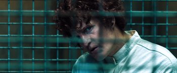 Movie still from “Venom” (2018), directed by Ruben Fleischer – A man with blue eyes is behind bars; Close Up shot, High angle
