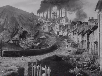 Movie still from “How Green Was My Valley” (1941), directed by John Ford – A black - and - white photo of a town with smoke billowing out of the chimneys; Extreme Wide shot, High angle