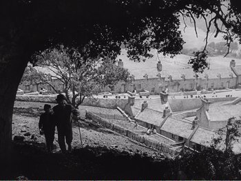 Movie still from “How Green Was My Valley” (1941), directed by John Ford – Two people standing on a hill looking at a castle; Extreme Wide shot, High angle