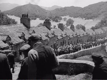 Movie still from “How Green Was My Valley” (1941), directed by John Ford – A black and white photo of a group of people standing on a hill; Extreme Wide shot, High angle