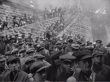 Movie still from “How Green Was My Valley” (1941), directed by John Ford – A group of men standing next to each other on some steps; Wide shot, High angle