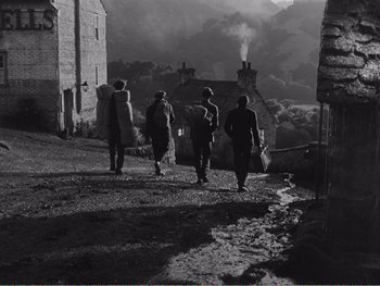 Movie still from “How Green Was My Valley” (1941), directed by John Ford – A group of people walking down a street; Wide shot, High angle