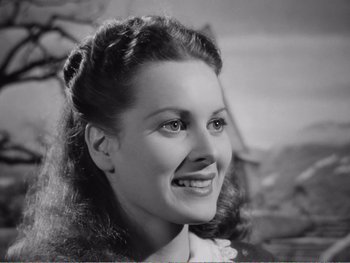 Movie still from “How Green Was My Valley” (1941), directed by John Ford – An old black and white photo of a woman smiling for the camera; Close Up shot, High angle