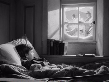 Movie still from “How Green Was My Valley” (1941), directed by John Ford – A little boy laying in a bed looking out a window; Wide shot, High angle