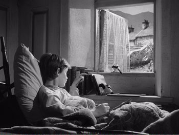 Movie still from “How Green Was My Valley” (1941), directed by John Ford – A little girl sitting in a bed looking out a window; Wide shot, High angle
