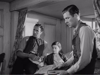 Movie still from “How Green Was My Valley” (1941), directed by John Ford – A man and a woman sitting next to a little girl; Medium shot, Low angle